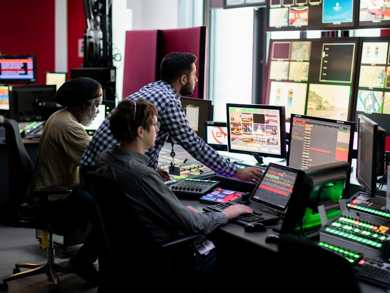 Black systems engineer monitoring infrastructure in a control room
